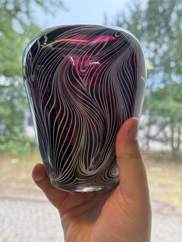 The vase held up to the light, allowing you to see its translucent purple core