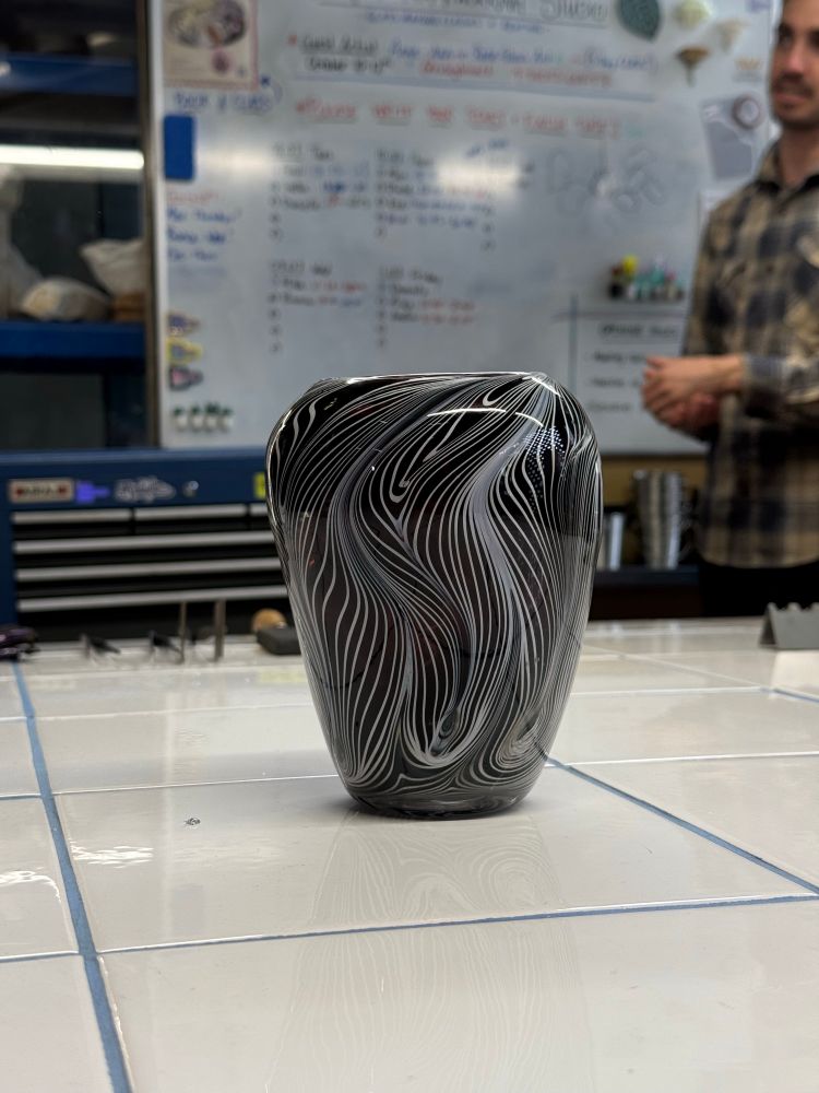 A simple vase with swirly white lines across a dark core