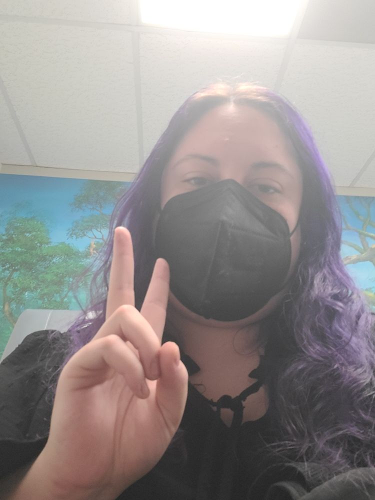 Me throwing a peace sign at the camera with a black n95 mask on