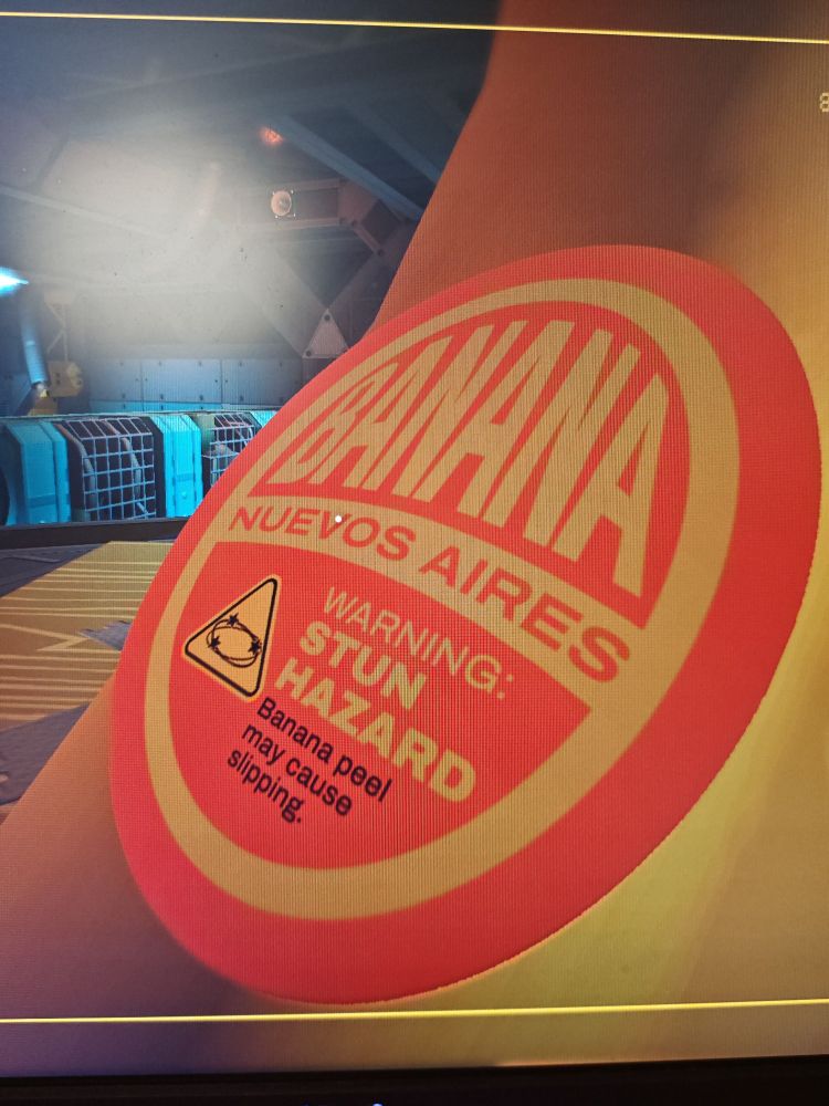 Sticker on a Banana tool/weapon "Banana Nuevos Aires. Warning: Stun Hazard. Banana peel may cause slipping"