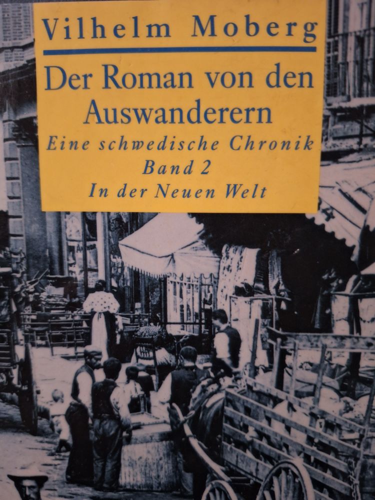 Cover des Buchs: Der Roman von den Auswanderern, Eine schwedische Chronik, Band 2, In der neuen Welt. Von Vilhelm Moberg.
Auf dem Cover ist eine Fotografie von ca. 1850 abgebildet, eine Marktszene mit Fuhrwerk
