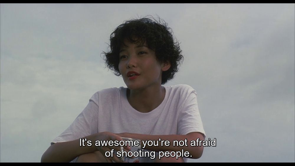 Screenshot from Sonatine (1993). A woman says: "It's awesome you're not afraid of shooting people."
