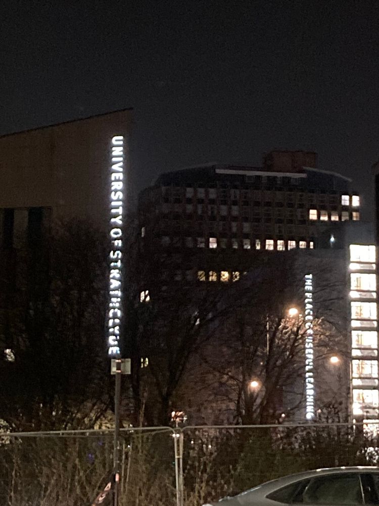 Night view of University of Strathclyde buildings with illuminated signs 