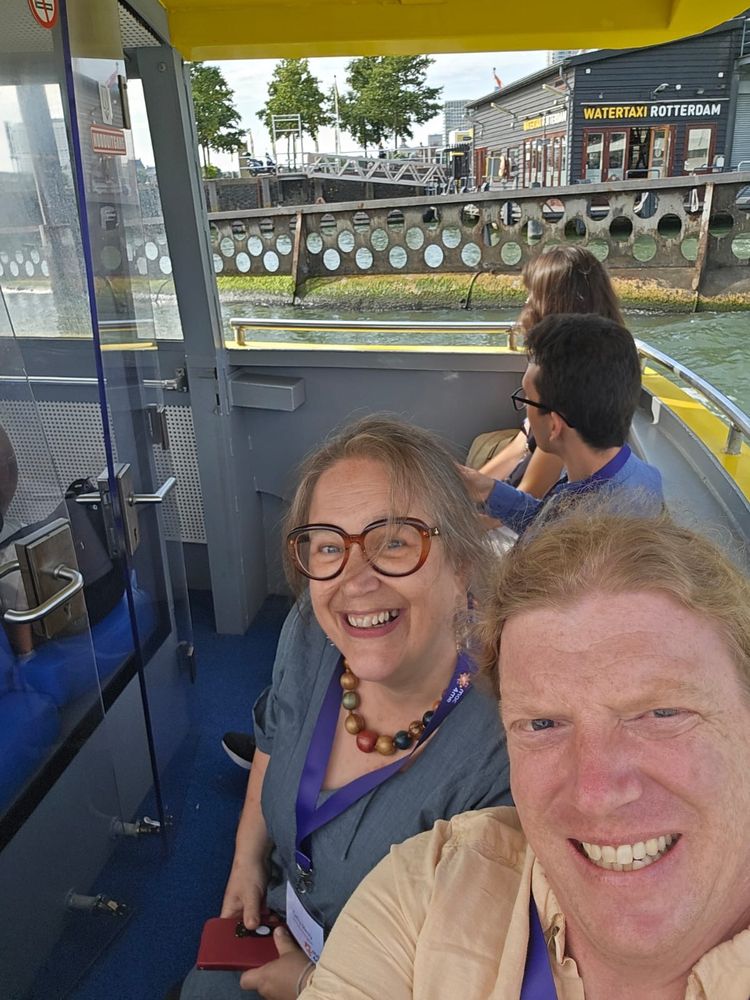 Two grinning people on a boat