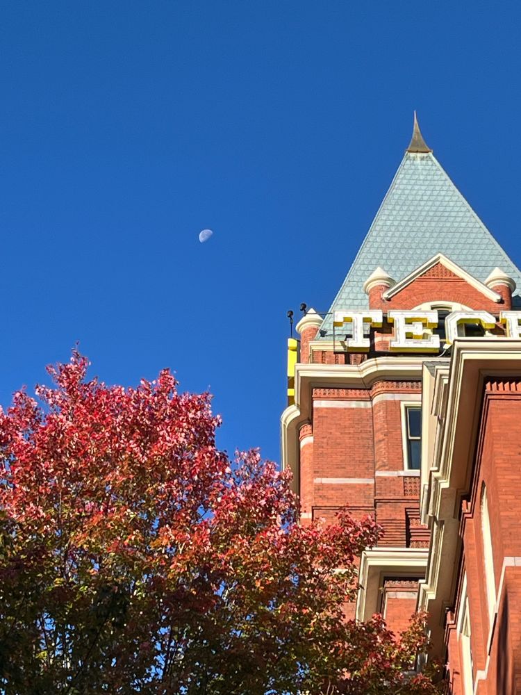Tech tower on Georgia Tech’s main campus under a blue sky (with a half moon)