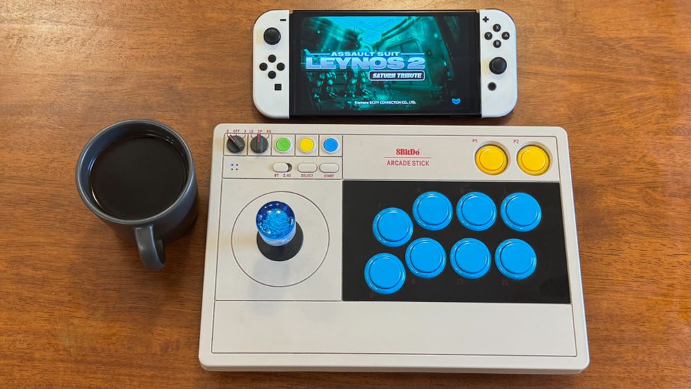 Assault Suits Leynos 2 Saturn Tribute playing on a Switch, with a fancy joystick and a cuppa Joe.