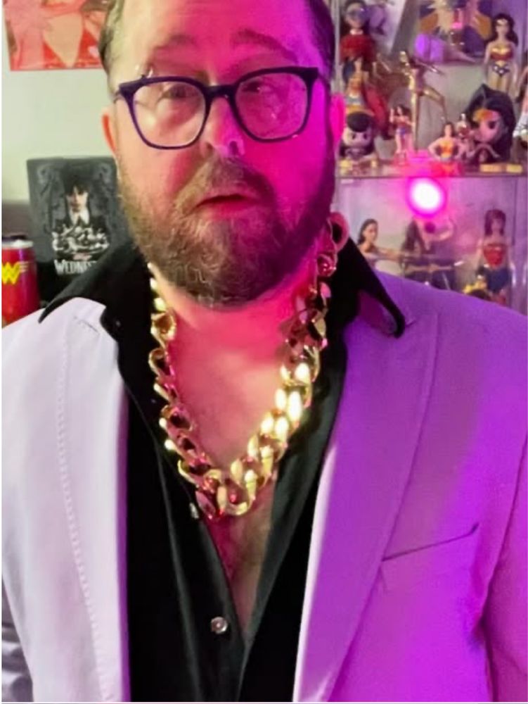 Allan Mott were no a retro leisure suit and an incredibly thick braided gold chain 