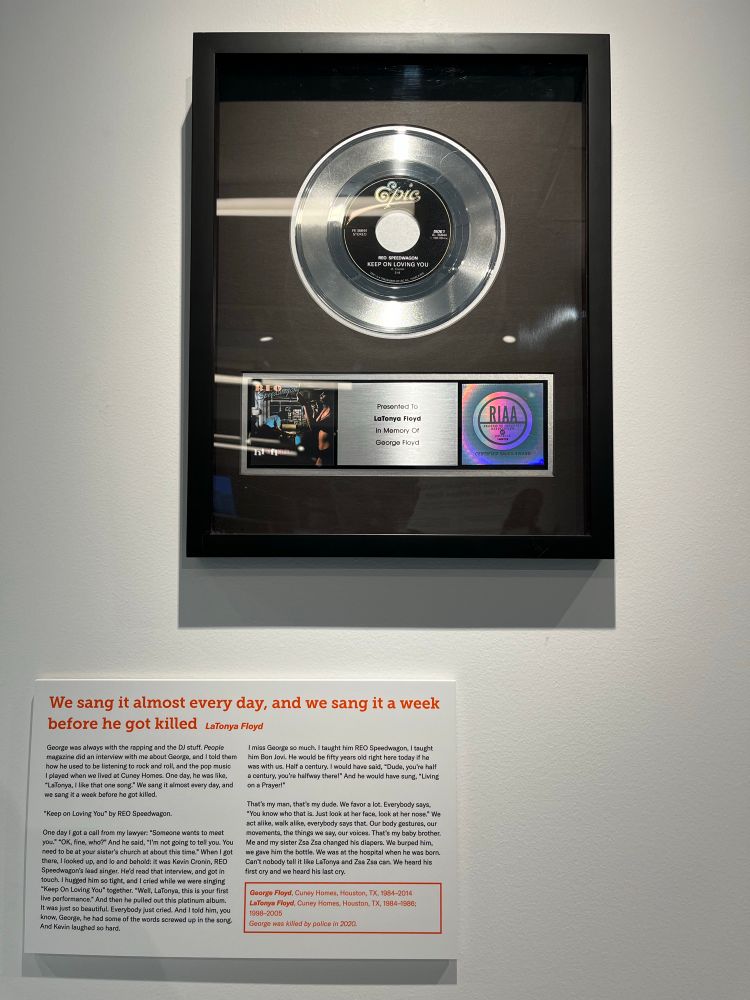A ceremonial platinum record and explanatory wall text on a museum wall. The text details George Floyd and his sister LaTonya’s shared love of this song.