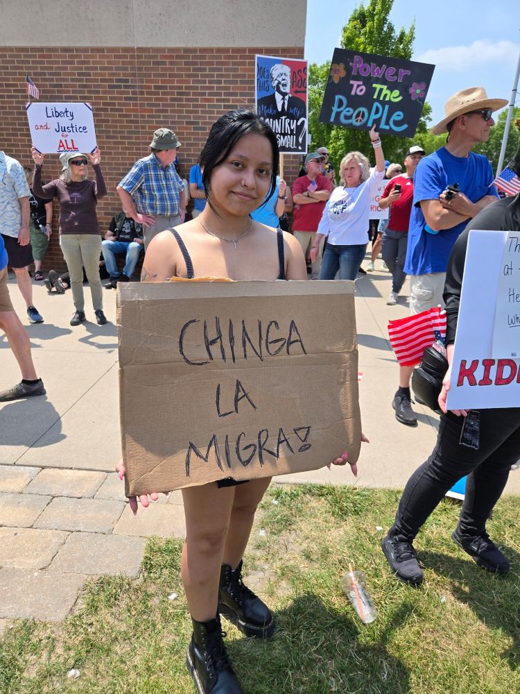 Sign says: Chinga la migra!
Translation: fuck ice
