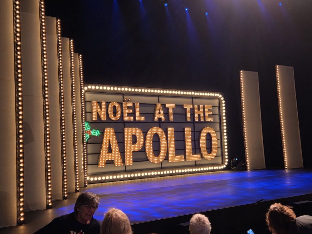 Noel at the Apollo stage with backdrop