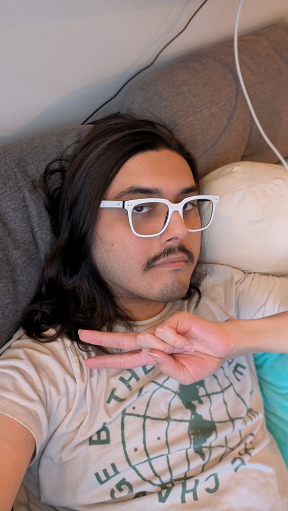 A photo of me, sporting my new mustache. I'm throwing up a peace sign.