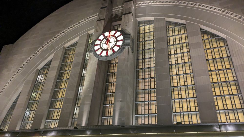 The front face of the terminal at midnight as I arrived for my late night departure. The windows are a glowing yellow with a lovely lit clock at the center of the semicircular art deco front.