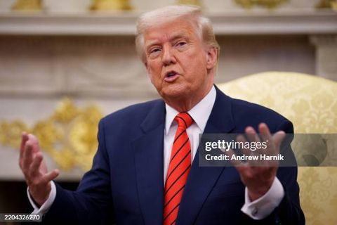 Donald Trump in the oval office, sitting on a yellow damask chair. His face is full.