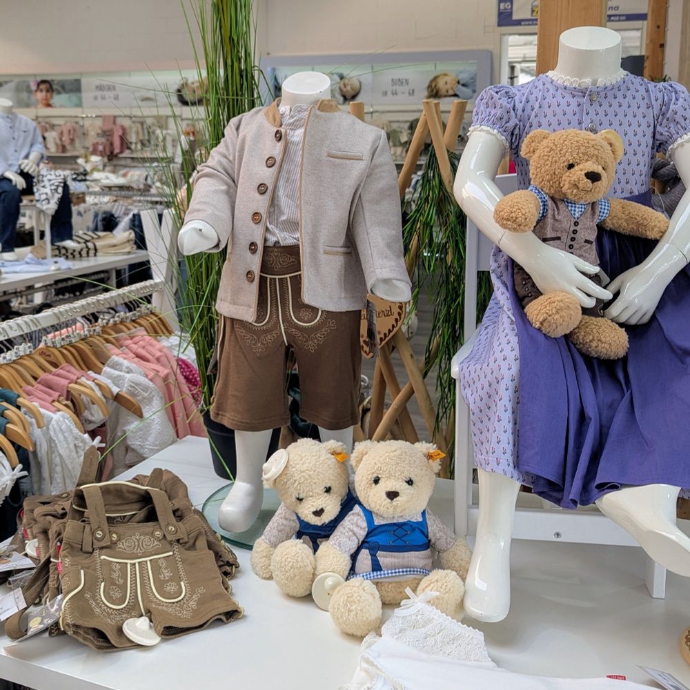 A collection of traditional Bavarian outfits on display in a children's store.