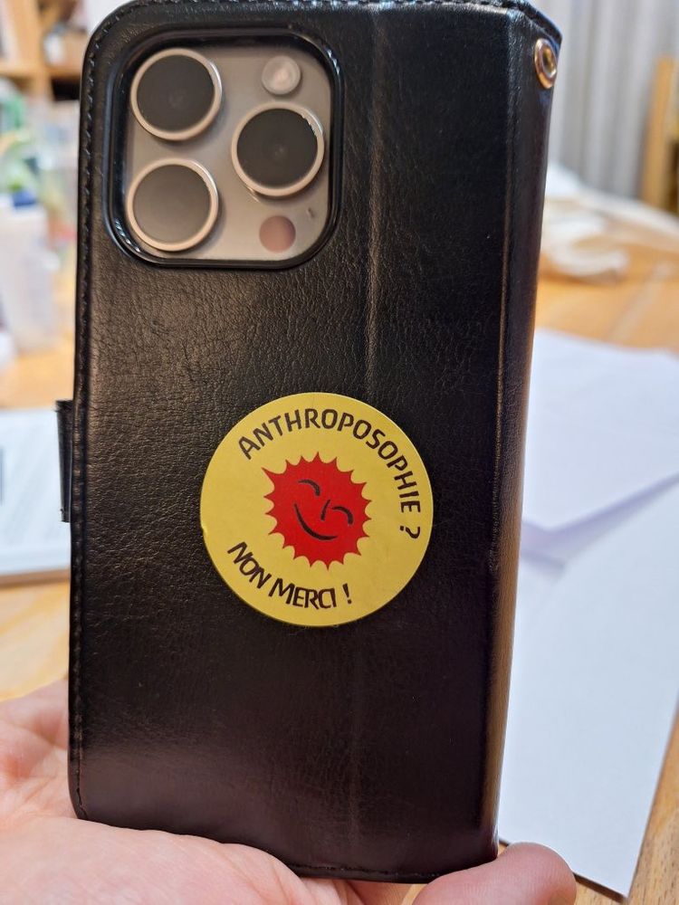 Téléphone avec un autocollant "anthroposophie non merci" 