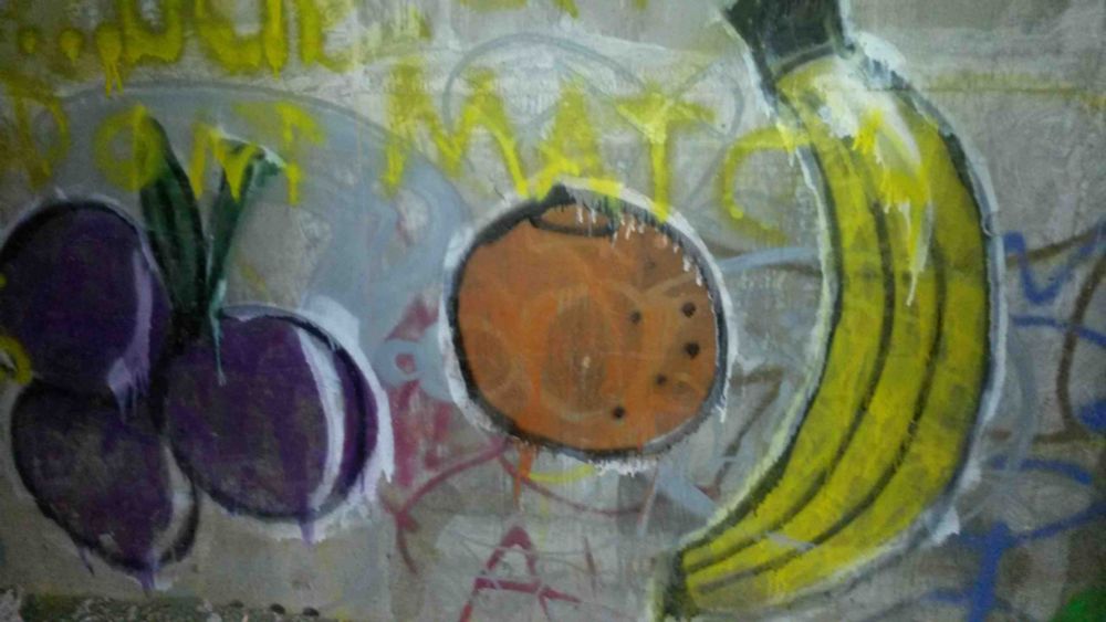 Street art mural looks like a still life with plums, an orange, and a banana.