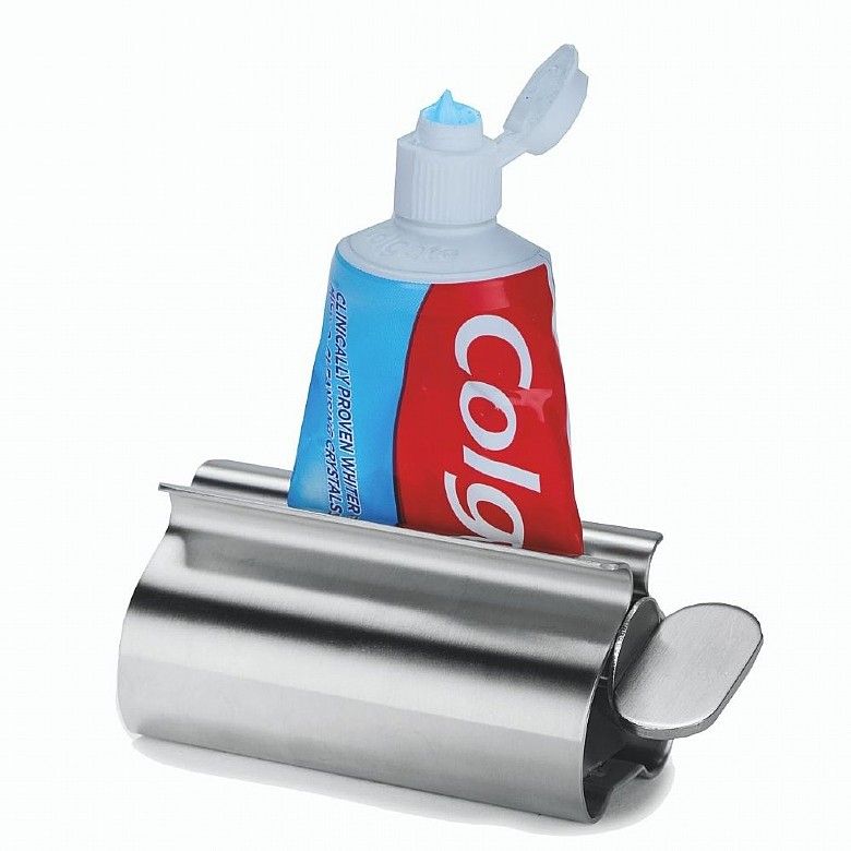 A metal tube squeezer with a tube of tooth paste in it. 
