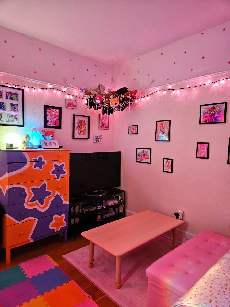 photo of a bedroom with lots of pastel pinks, lights and stuffed animals