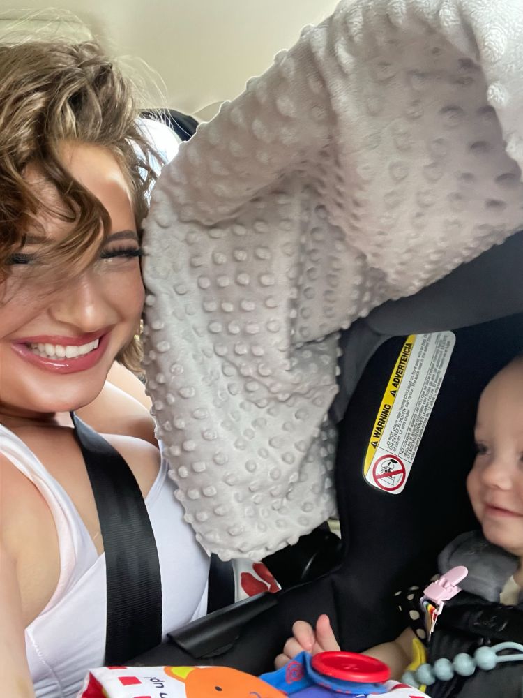 Picture of the baby smiling at me from his car seat as I smile at the camera after making funny faces to get him to smile💕