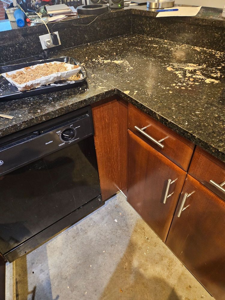 Cake crumbs smeared on a black stone counter and a plate full of mashed cake crumbs