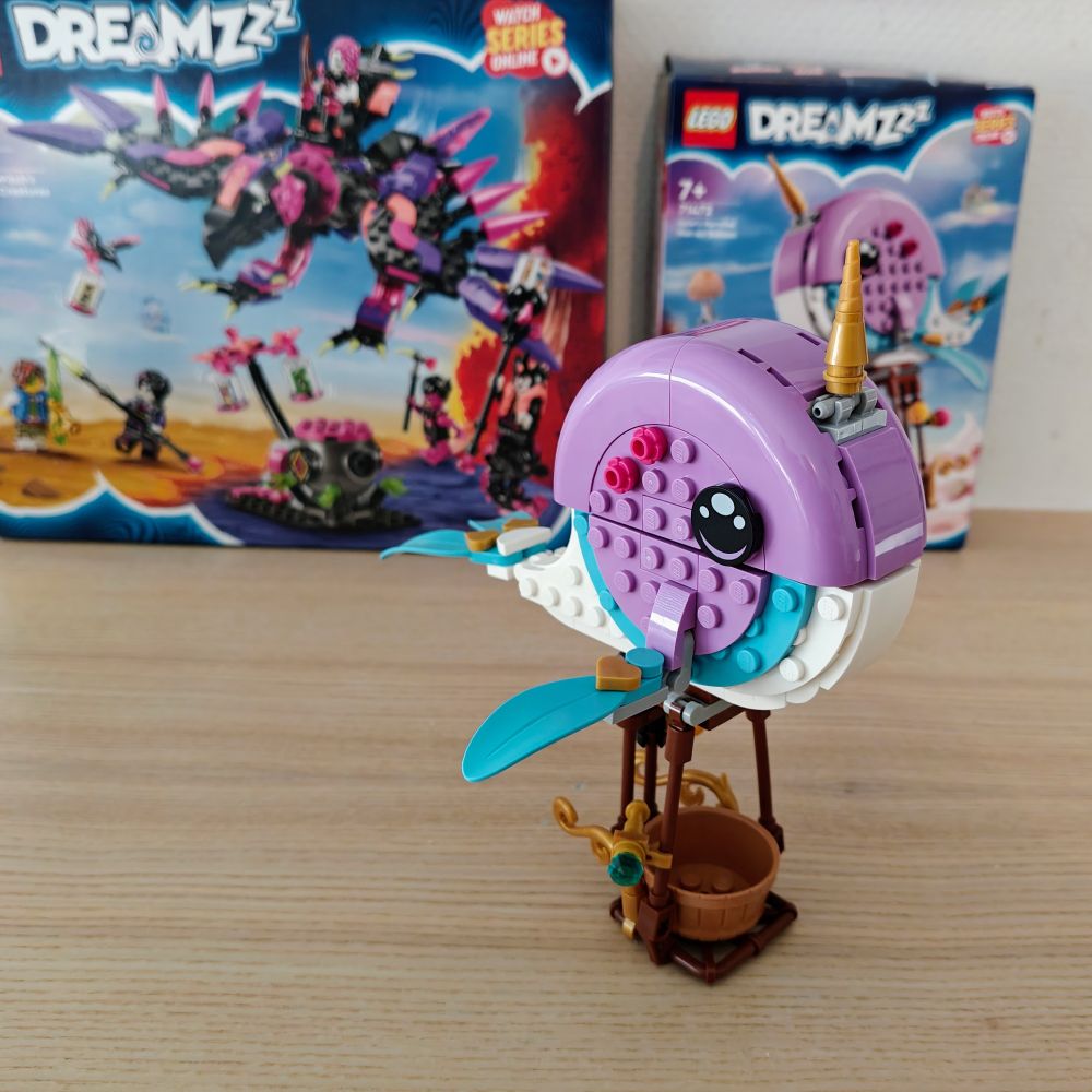 a picture of a build LEGO set from the Dreamzzz line. The set is a hot air balloon in the shape of a pink, white, and teal narwhal. In the background the boxes of this LEGO set, and an additional one (Nightmare Creatures) are also visible