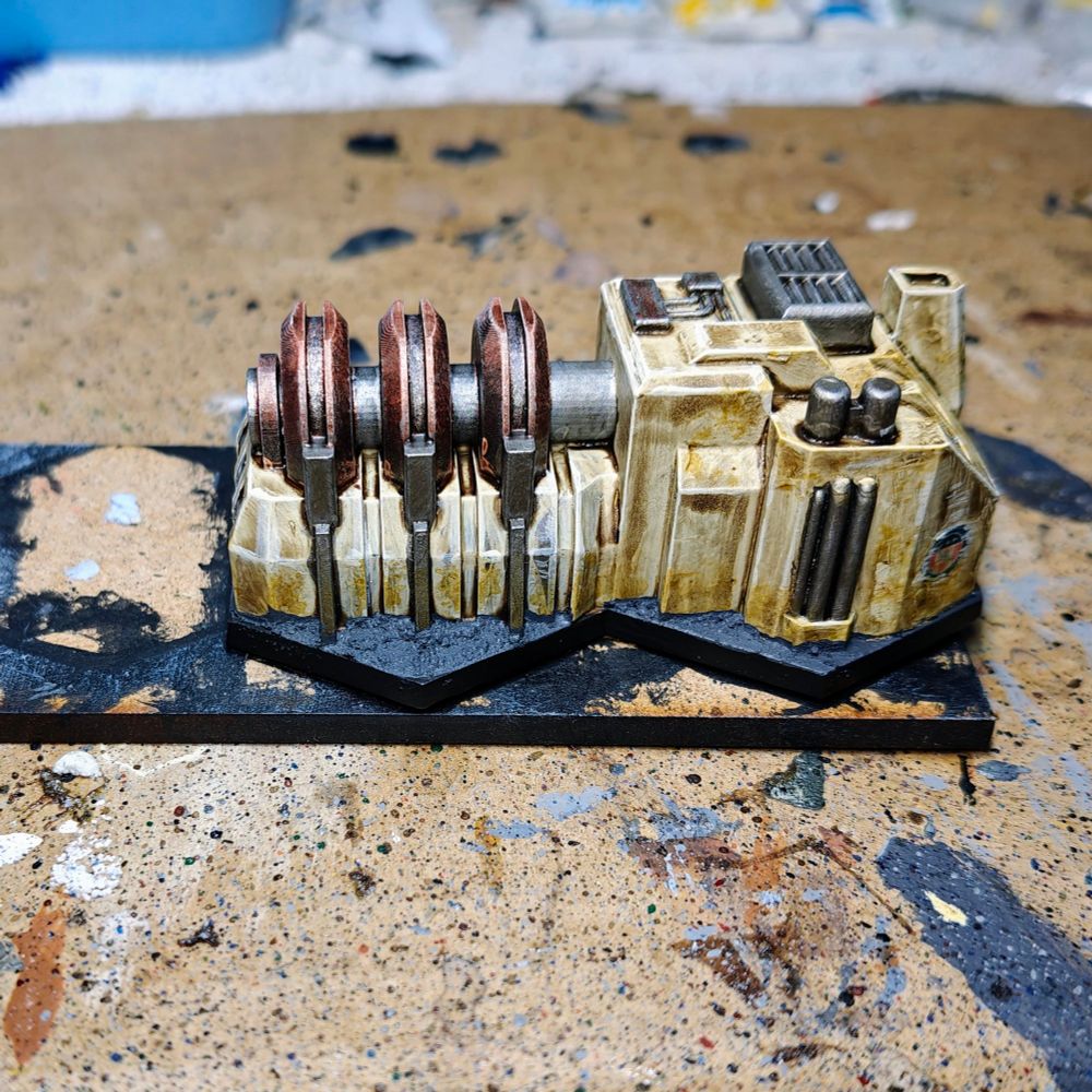 Left side picture of a 6mm scale piece of terrain. The building is a power generator and has been painted mainly in kaki colour with metallic accents.
