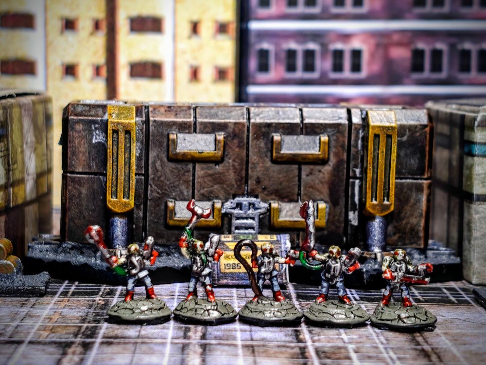 5 painted miniatures in 6mm scale. The miniature represent mutant/undead creatures with a humanoid shape. They have grey clothes with red boots and gloves and are carrying a variety of weapons (rifles, guns, swords, maces, and a whip) dirty with blood. 