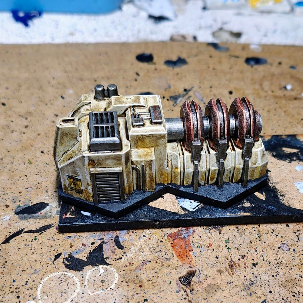 Right side picture of a 6mm scale piece of terrain. The building is a power generator and has been painted mainly in kaki colour with metallic accents.