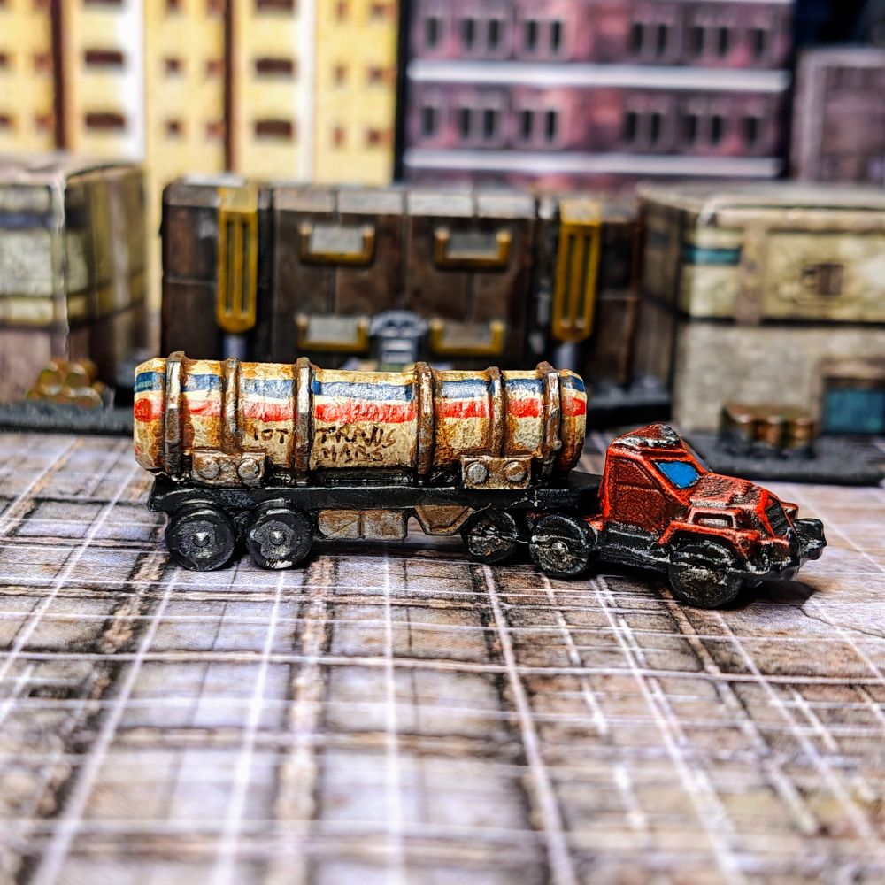 A picture of a 6mm scale truck (side view). The truck has a red engine and a tank trailer with the company name "Trans Mars" written on the side.