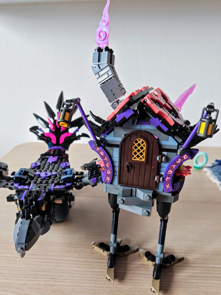 A walking hut and a large raven built out of LEGO. These are part of the Nightmare Creatures LEGO DreamZzz set. The two items are mostly built in black and purple bricks