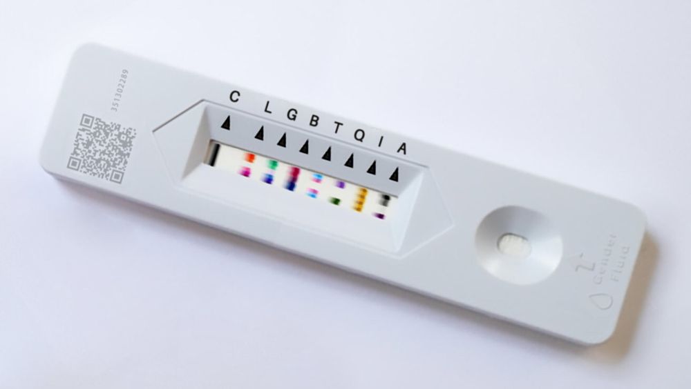 A photo of a rapid antigen looking test except it’s a multi tests with a control strip and also L G B T G I and A strips all across the one test. All of the strips are activated in the colours of the pride flags for each of LGBTQIA.