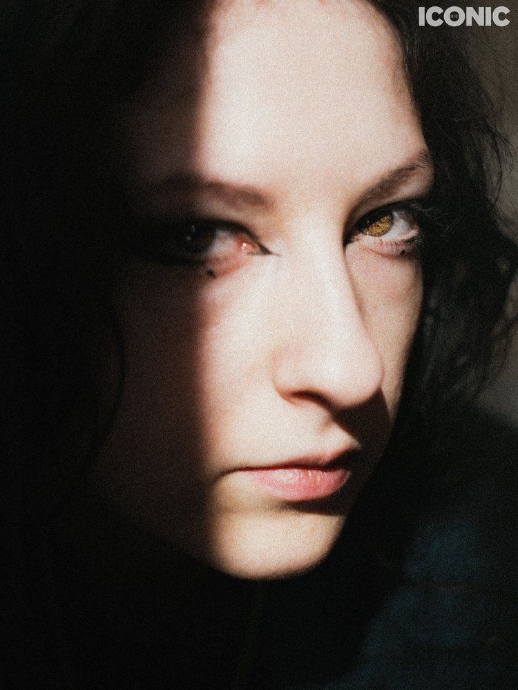 Portrait of an androgynous person lit by the sunlight, film like feel, warm colors. Half the right eye is in the shadow