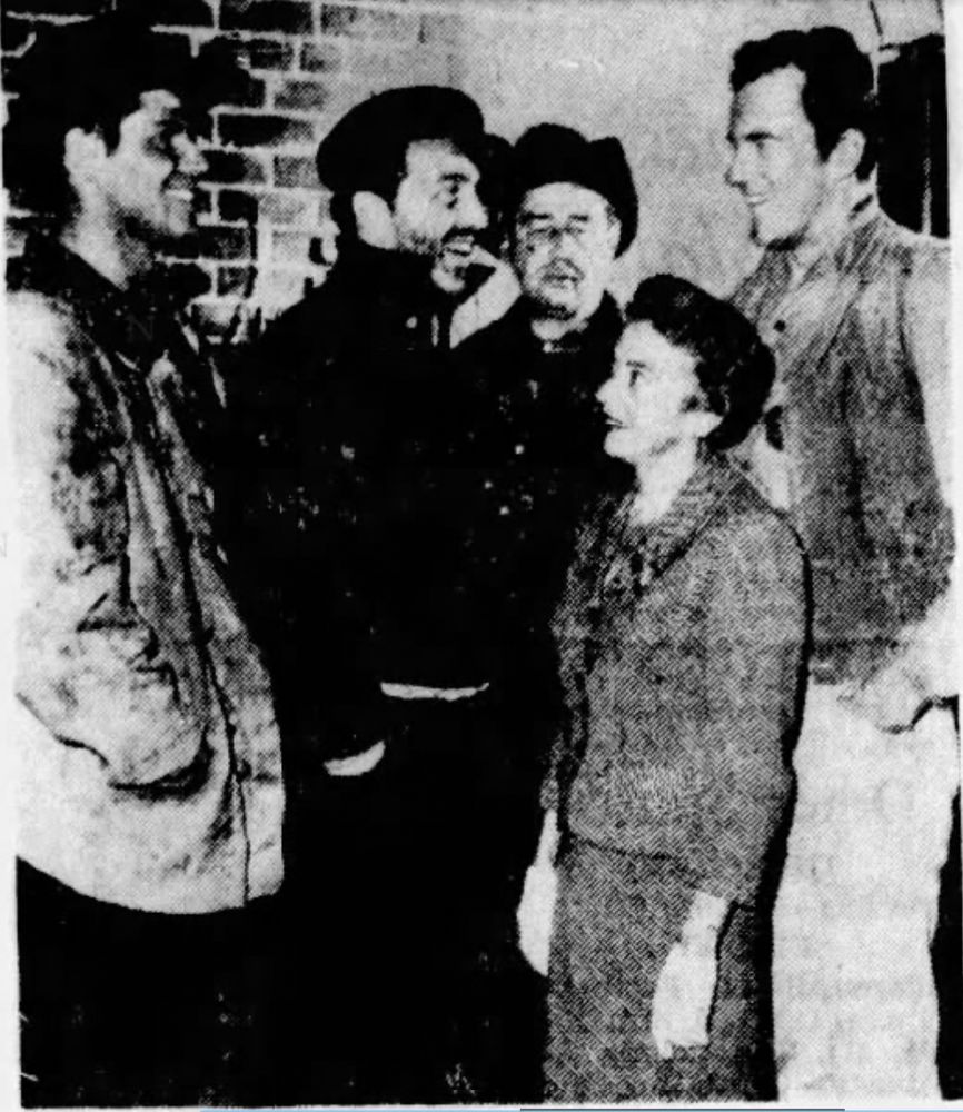 Writer Kathleen Hite and actor James Arness chat with other performers behind the scenes on Gunsmoke. 