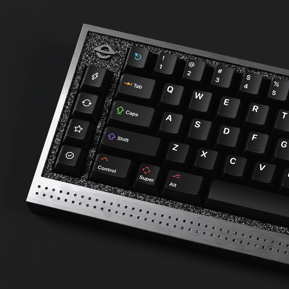 An angled black and brushed metal mechanical keyboard with a 65% layout, with black keycaps and white legends, with several icons in bright colours, and several ‘novelty’ keys showing icons of a lightning bolt, rotating arrows, star and approval tick
