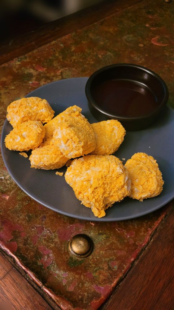 What appears to be chicken nuggets and a shallow bowl with perhaps barbecue sauce