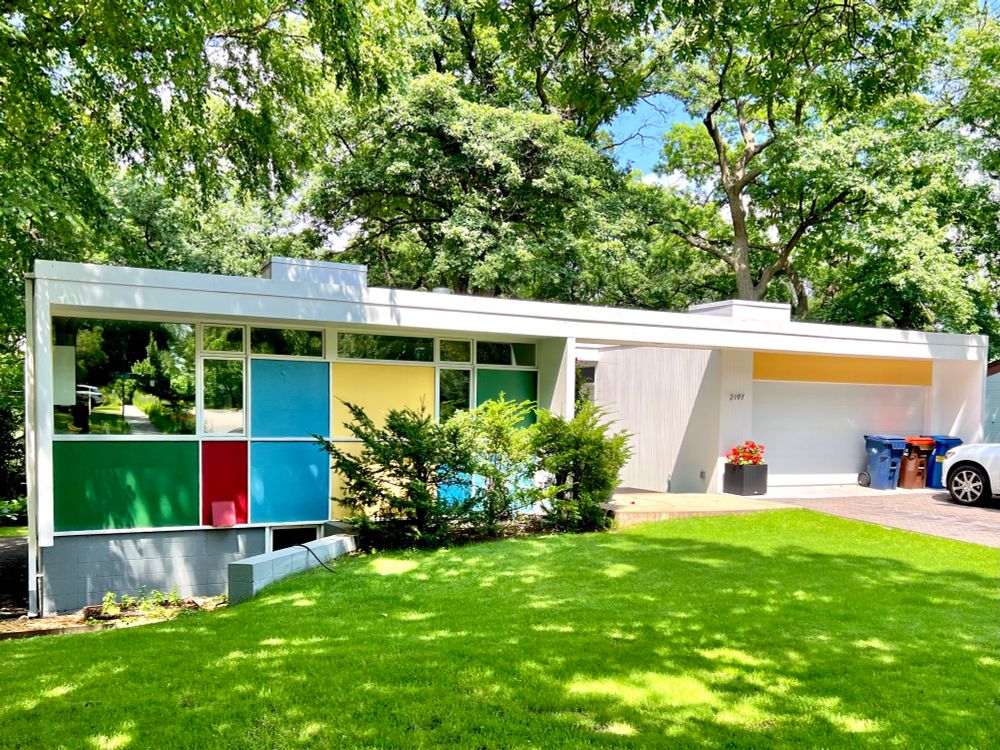 Boxy and simple white midcentury house with multi colored wall panels.
