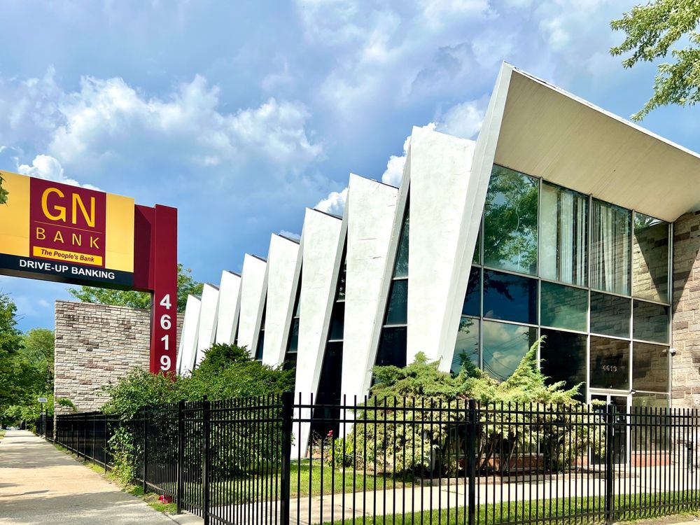 Midcentury building with a zigzag roofline and glass walls.