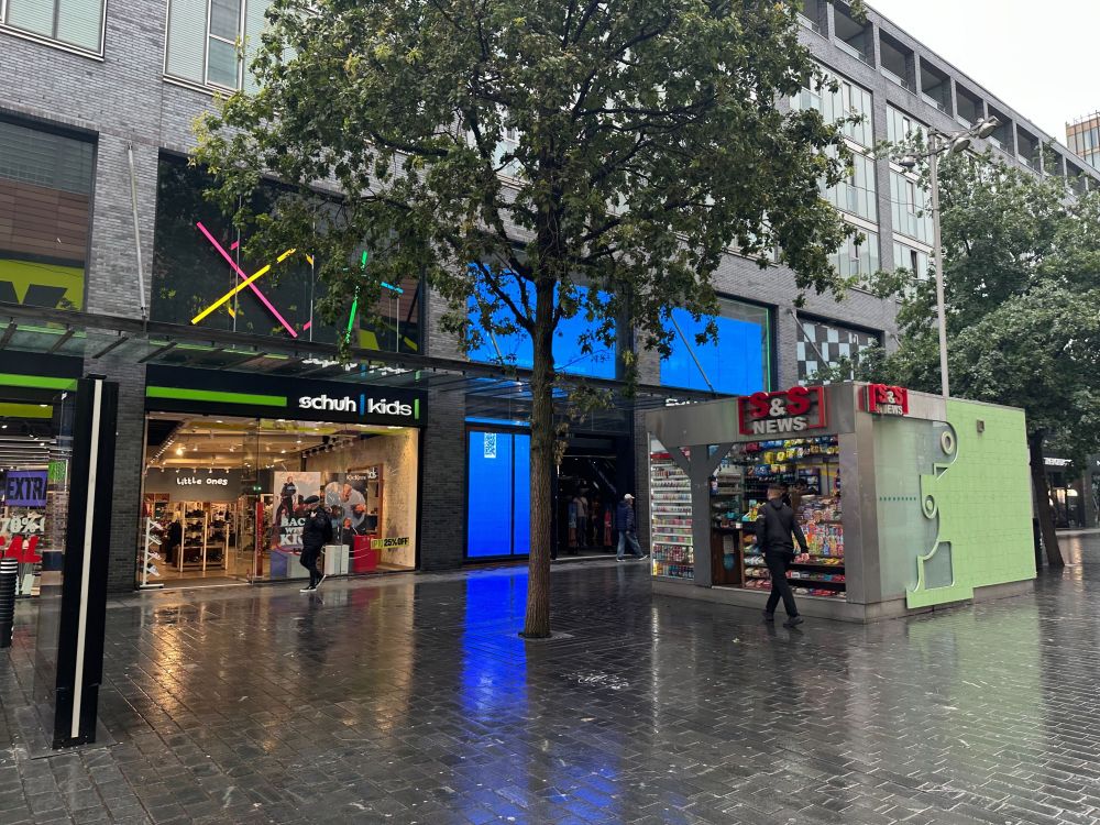 A shop front featuring mainly screens displaying a BSoD spread across them al