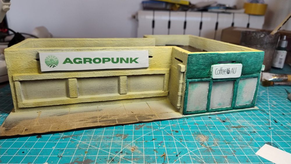 wargaming terrain MDF building representing a small department-store like business edifice. The shop signs feature an "Agropunk" and a "CoffeeAU" store.