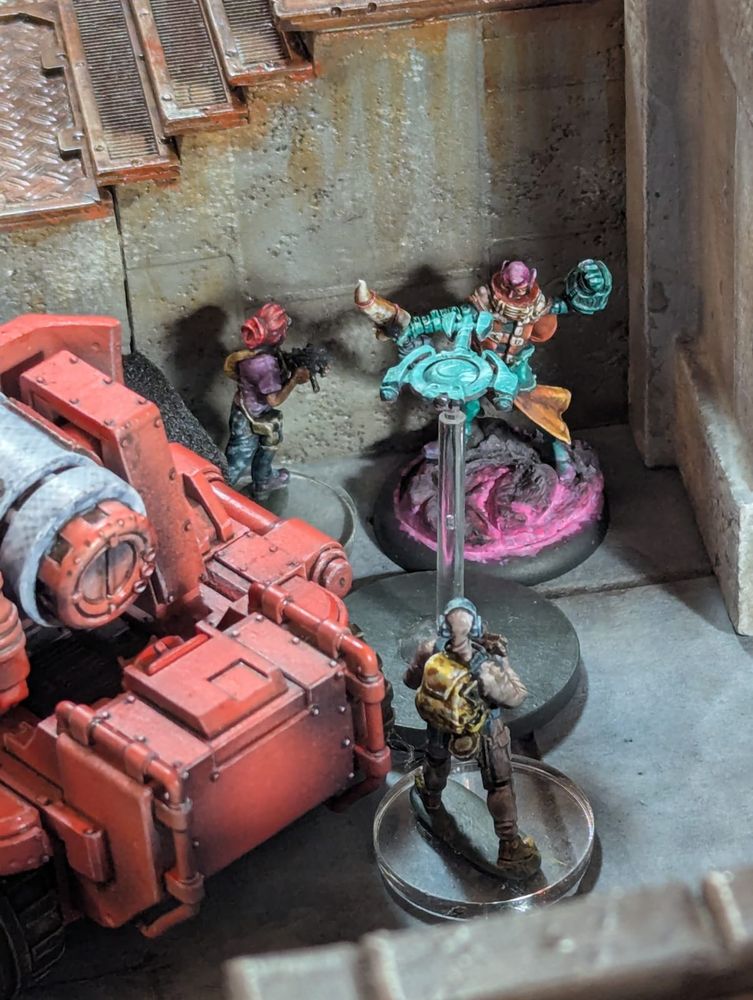 Splicer and escorted VIP hunker down behind a concrete stairway and a drone tank, while special operative with shotgun stands waiting for a target to cross into open terrain.