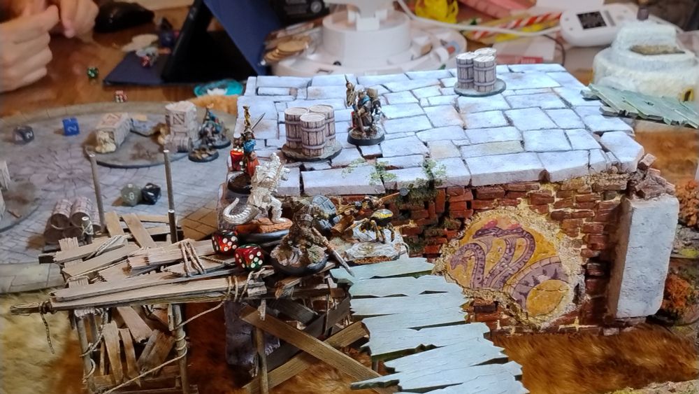 Atop the ruins fantasy types struggle in a miniature wargame