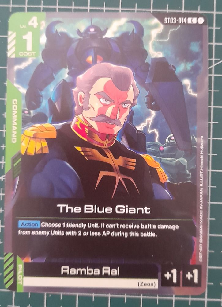 A photo of a Gundam TCG card featuring Ramba Ral from “Mobile Suit Gundam” looking menacing, there’s a Gouf in the background .
