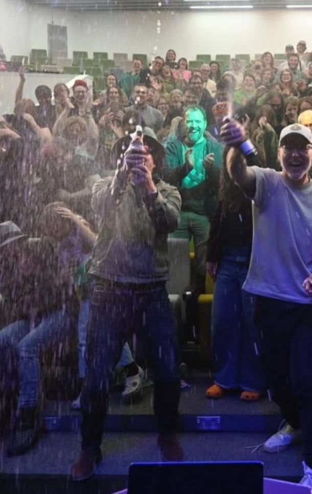 Rhys Darby popping champagne 