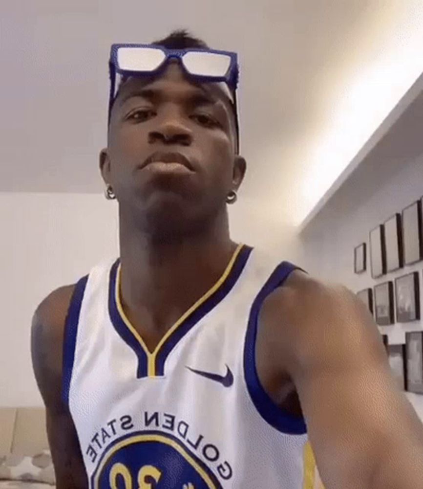 a man wearing a golden state warriors jersey is taking a selfie