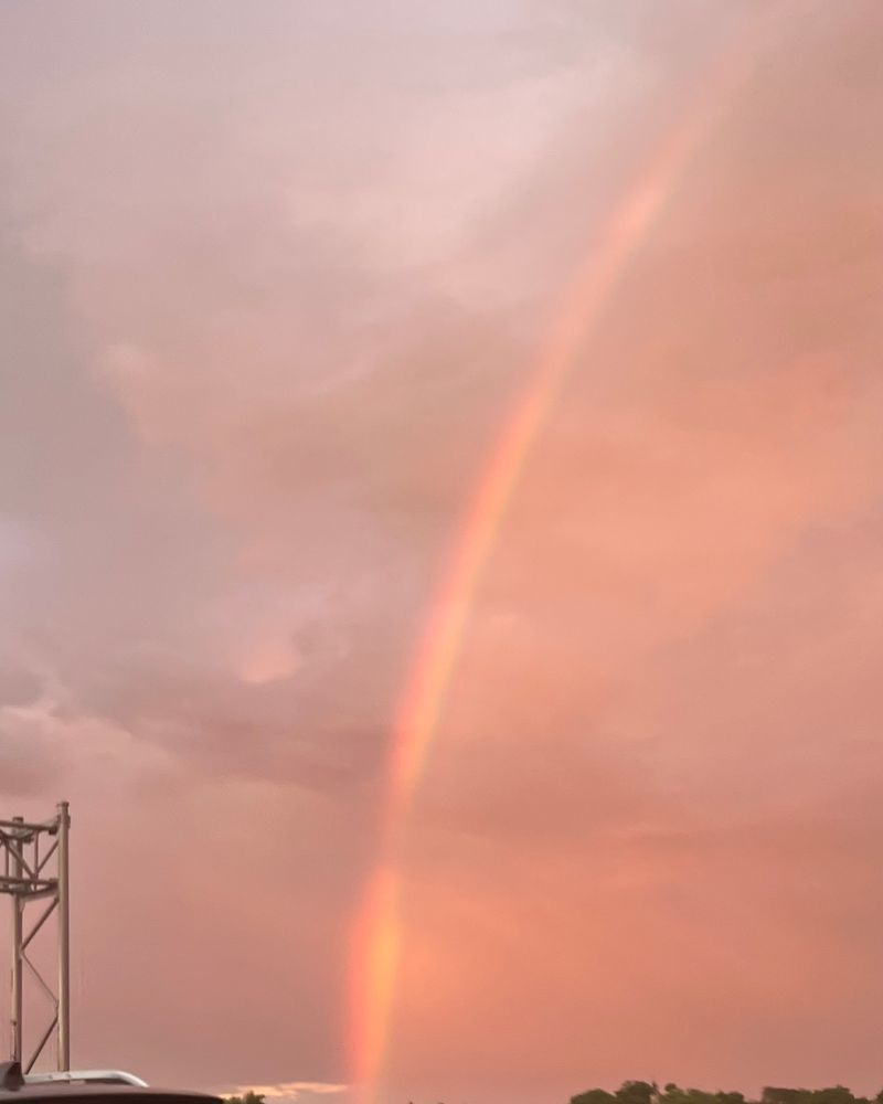 A bright rainbow against a cloudy sky off the highway 
