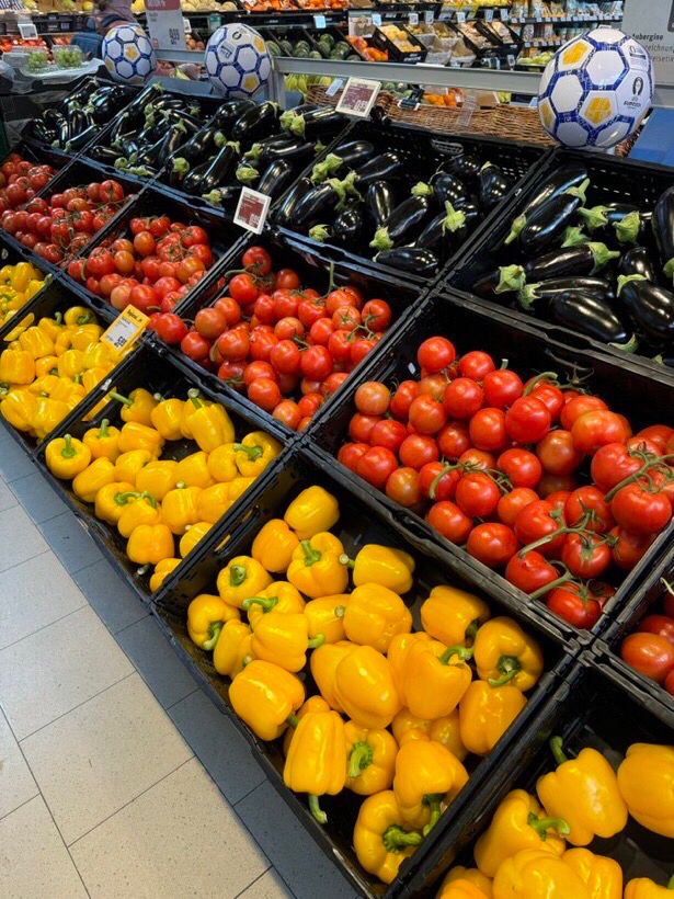 supermarkt gemüse abteilung 
die paprikas, tomaten und auberginen sind so angeordnet, dass sie die deutschland flagge bilden