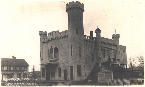 a side view of the Walcott castle hall, showing its messy mix of castle spires, window designs, and various styles of crenellation.