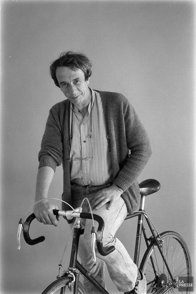 Pierre Foglia sourit sur sa bicyclette. 