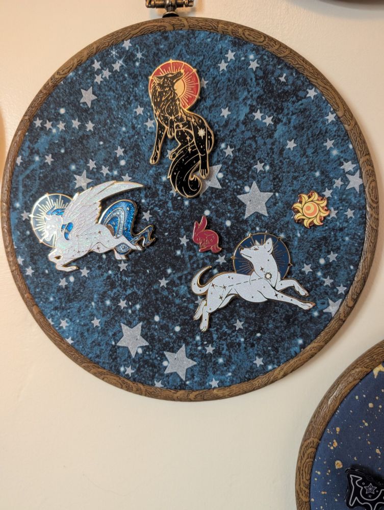A hoop with space for more pins from @chocolateraisinfury which are themed for the animals in the constellations.