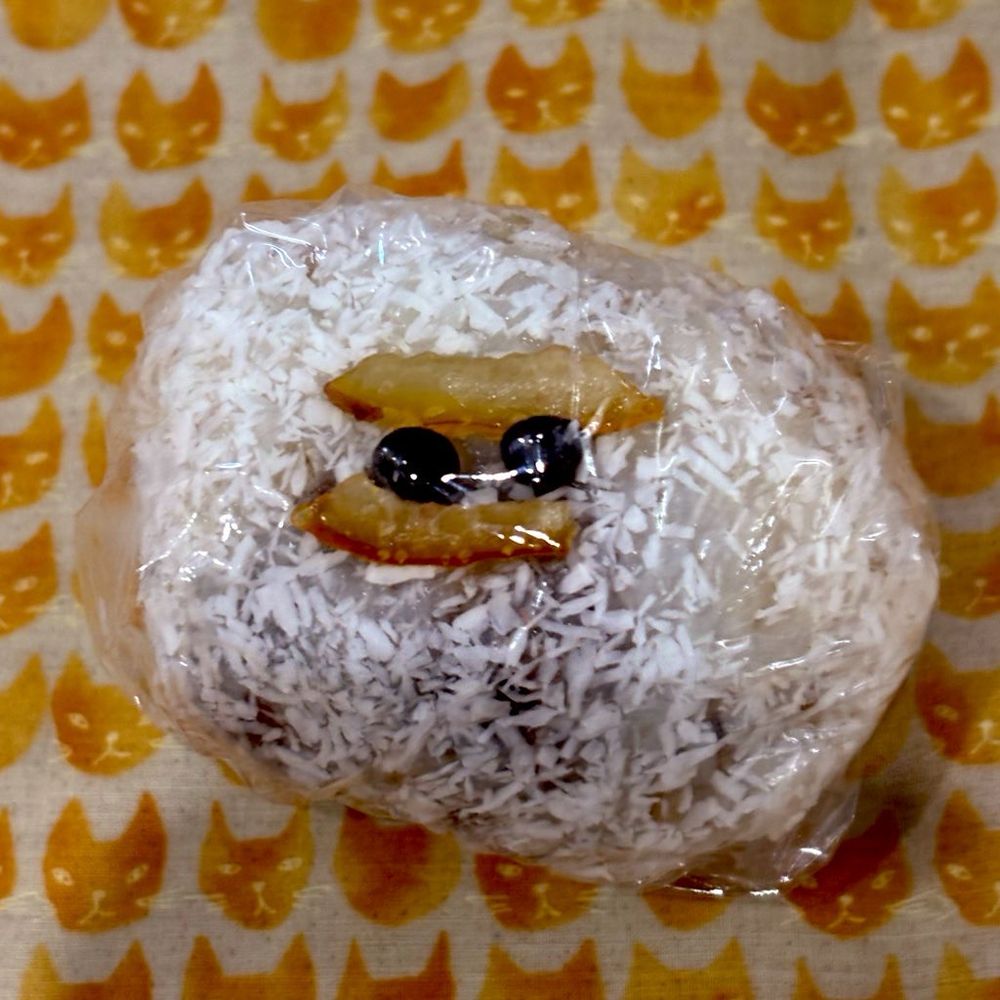 ココナッツがかかったおはぎ
オレンジピールと小さなチョコの粒が2個のっていて、目と眉毛のように見えなくもない